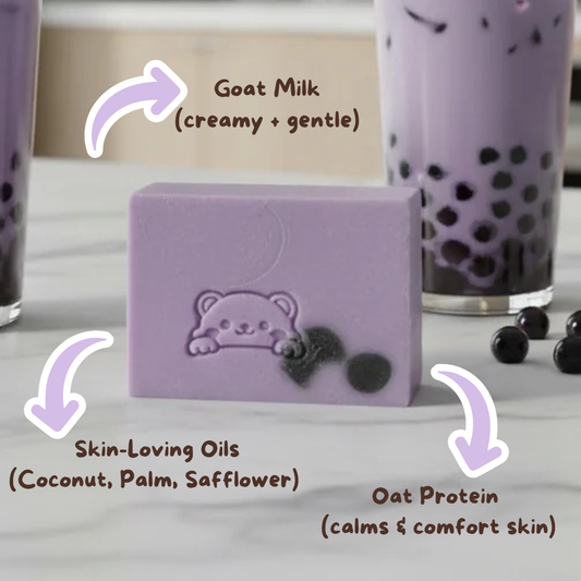 Purple soap bar with bear design on a white surface, surrounded by black tapioca pearls and a glass of bubble tea.