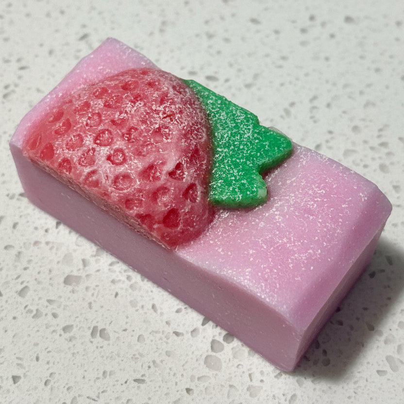 Bar of soap with strawberry design on a textured surface